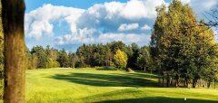 Golfové hřiště s trávou a stromy za slunečného dne