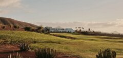Golfové hřiště s kaktusy a budovou v pozadí na Lanzarote