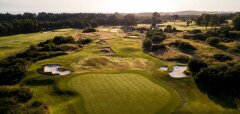 Golfové hřiště s greenem a pískovými bunkry za soumraku