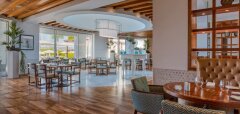 Interiér restaurace s dřevěnou podlahou a moderním nábytkem