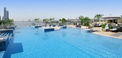Střešní bazén s lehátky a slunečníky v hotelu v Dubaji