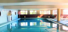 Interiérový bazén s lehátky a dekoracemi v Quinta Splendida Wellness