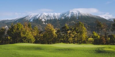 Golfové hřiště s horami a stromy v pozadí