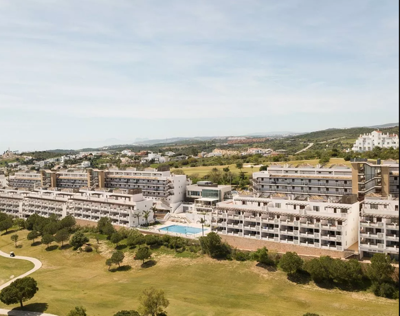 Golfové hřiště s bílými budovami a horou v pozadí