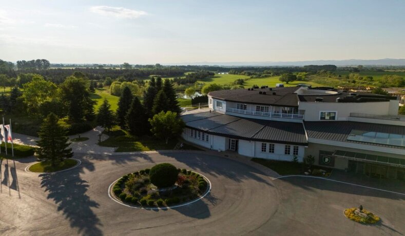 Budova golfového klubu s okolní zelení a golfovým hřištěm