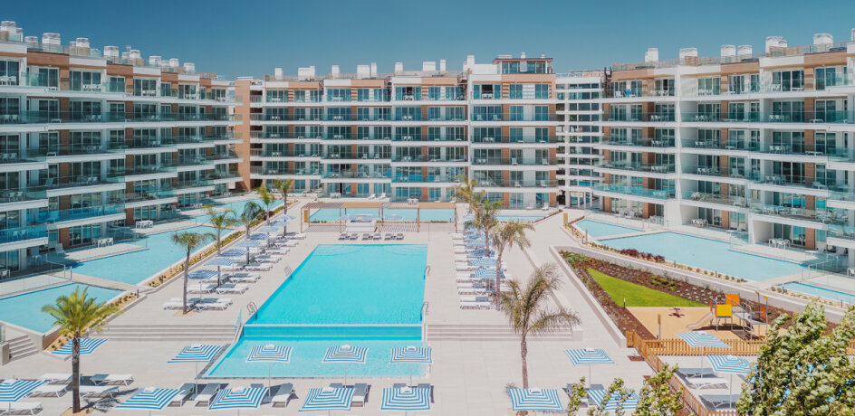 Moderní rezidenční komplex s bazény a palmami