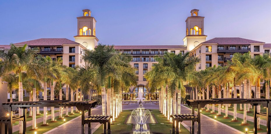 Lopesan Costa Meloneras Resort & Spa s palmami a fontánou večer