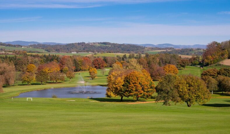 Golfové hřiště s jezírkem a podzimními stromy