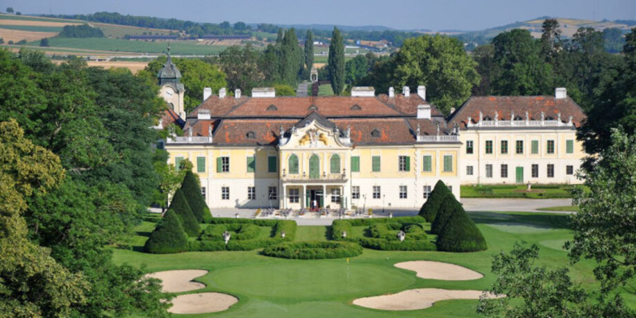 Zámek s upravenou zahradou a golfovým hřištěm v popředí