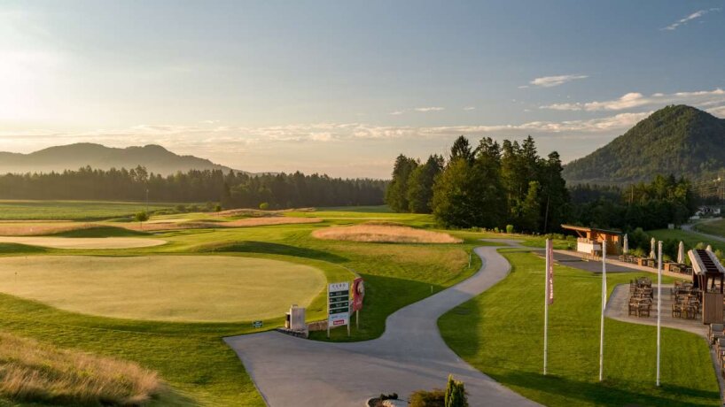 Golfové hřiště s cestou a stromy za soumraku