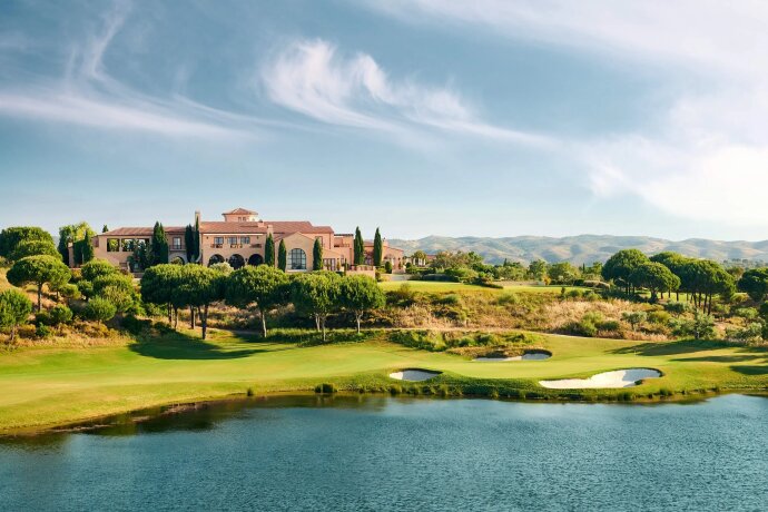 Golfové hřiště s jezírkem a budovou v pozadí
